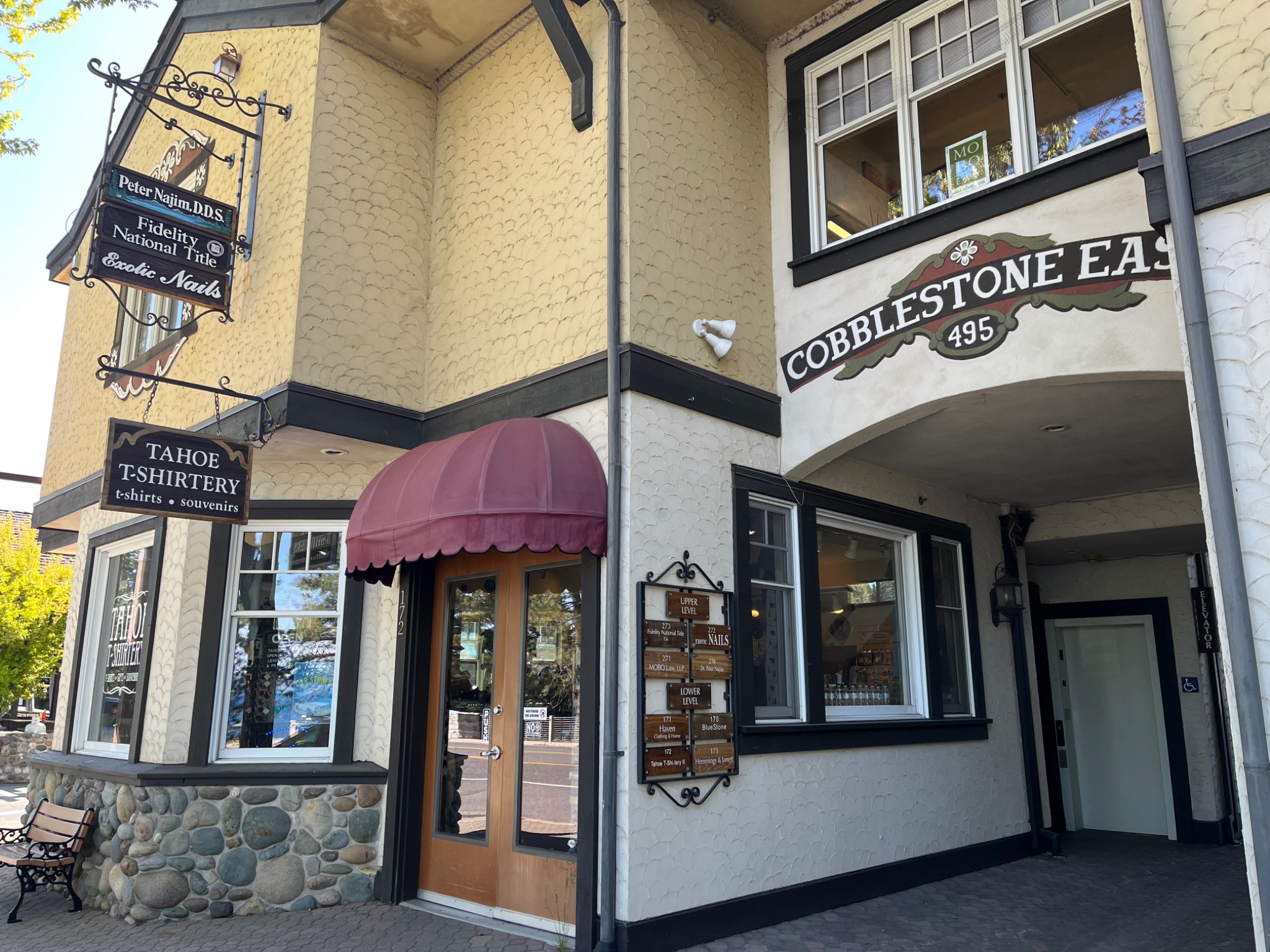 The warm exterior of Cobblestone East with a rose-colored awning